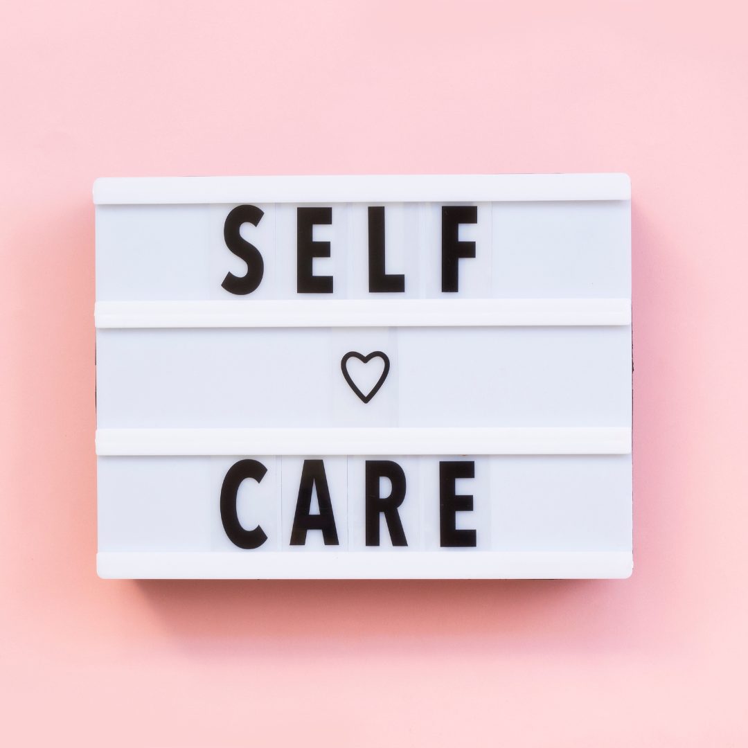 Lightbox sign reading SELF heart CARE on pink background