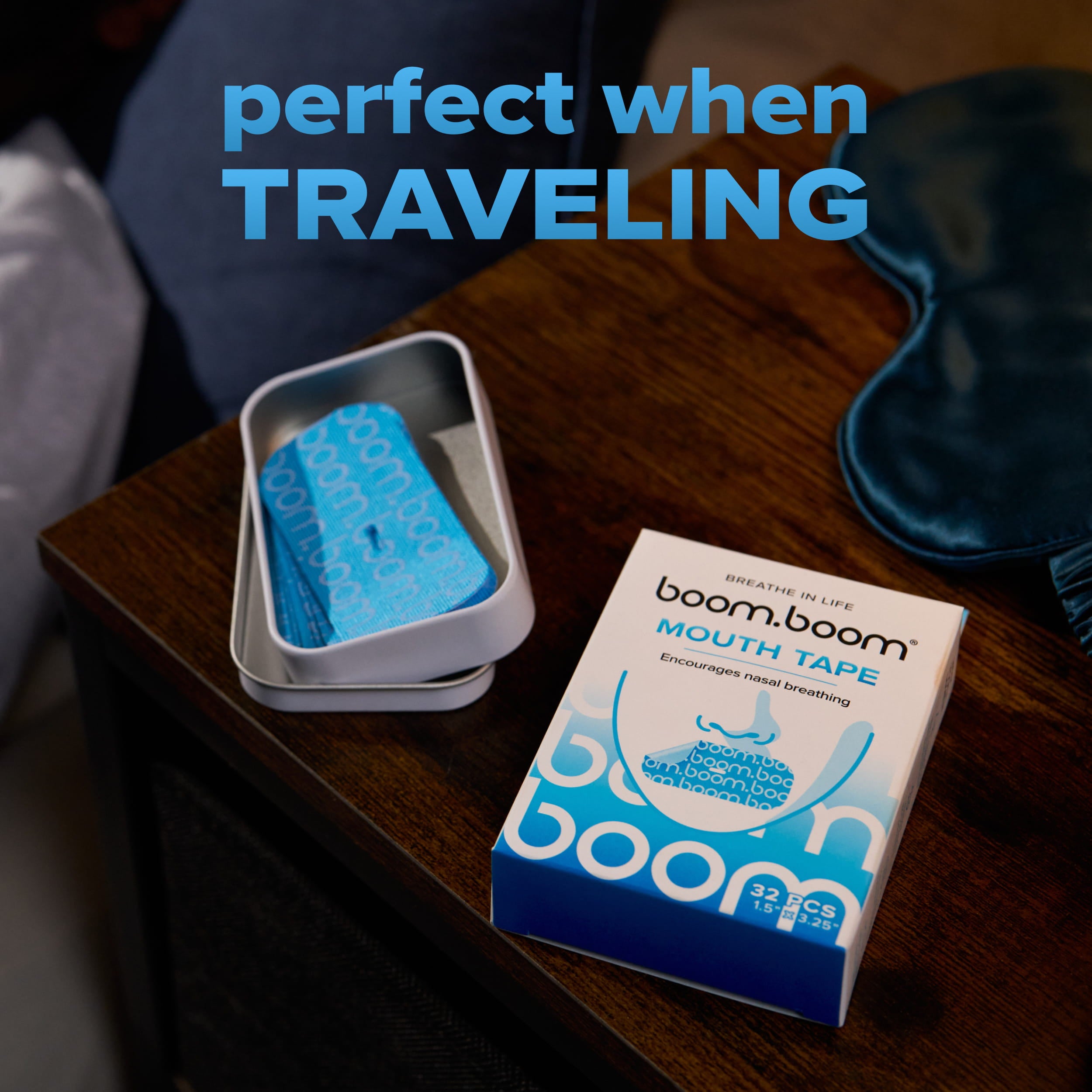 Angled top view of Mouth Tape container open to show blue tape strips and product box on a bedside table with overlay text perfect when traveling