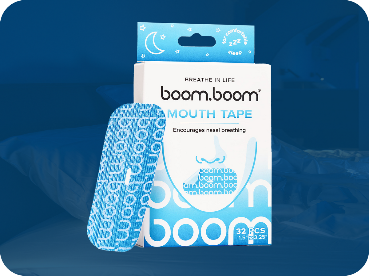 Front view of BoomBoom mouth tape box with blue patterned strip, ‘Mouth Tape’ text, dark bedroom background